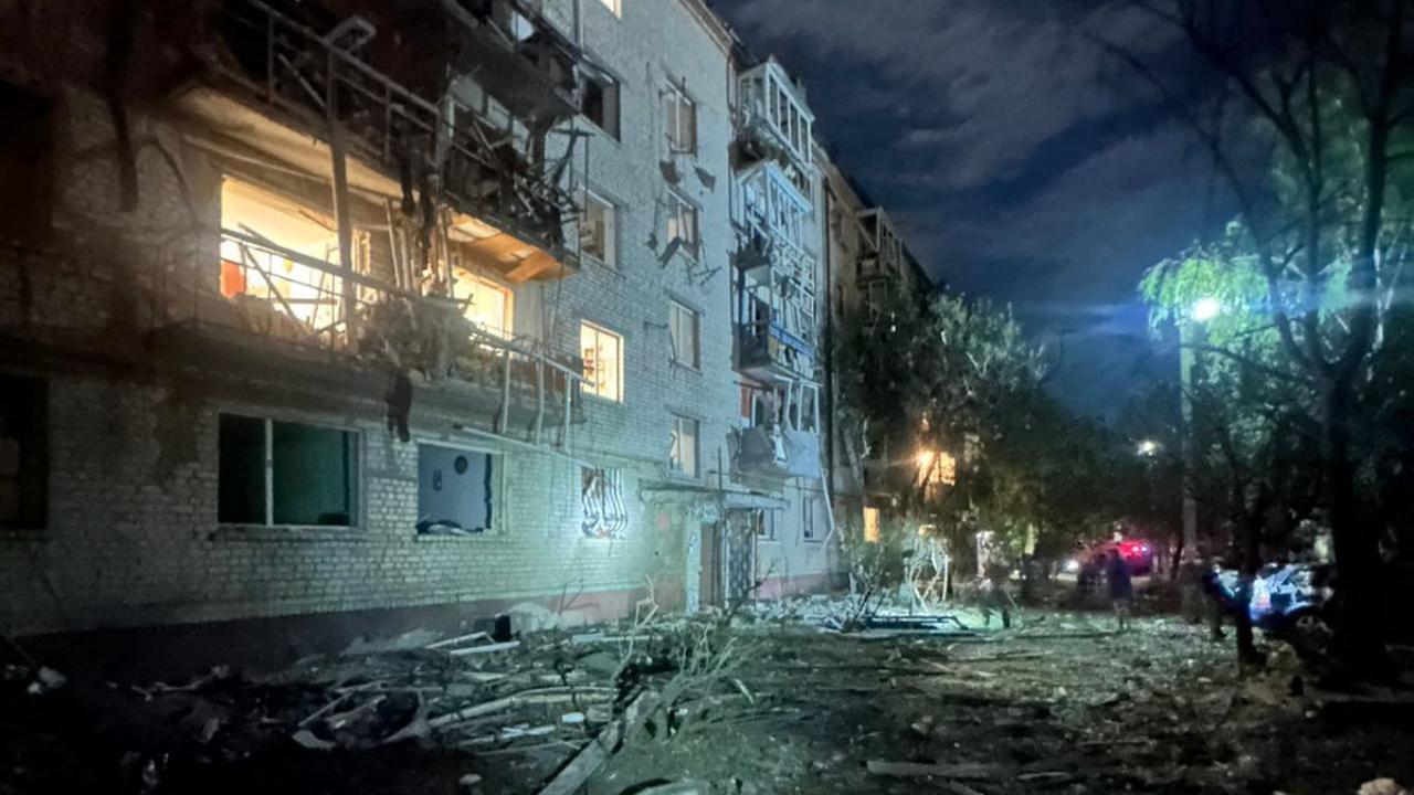 Ein beschädigtes Haus, davor liegen Trümmer auf der Straße. Ein beschädigtes Haus, davor liegen Trümmer auf der Straße.