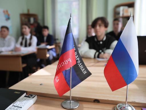 In dieser Schule im ukrainischen Donetzk stehen vorne auf dem Lehrertisch die Fahnen Russlands und der selbsternannten Volksrepublik Donezk. 