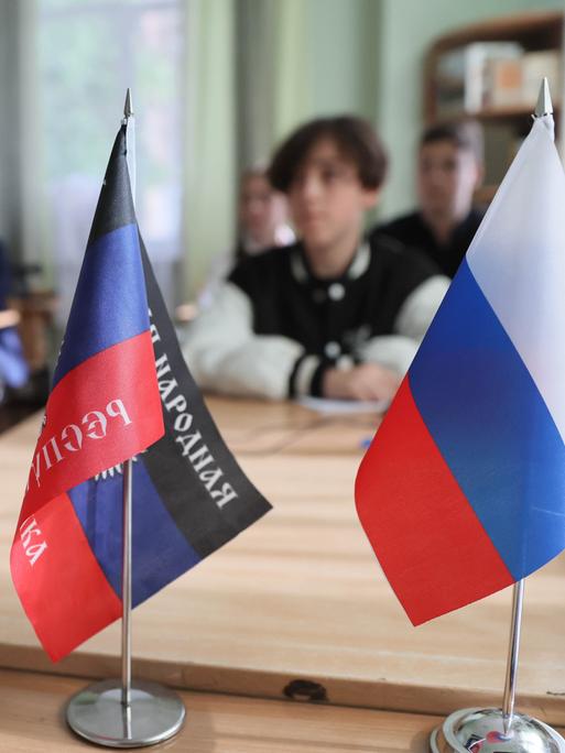 In dieser Schule im ukrainischen Donetzk stehen vorne auf dem Lehrertisch die Fahnen Russlands und der selbsternannten Volksrepublik Donezk. 