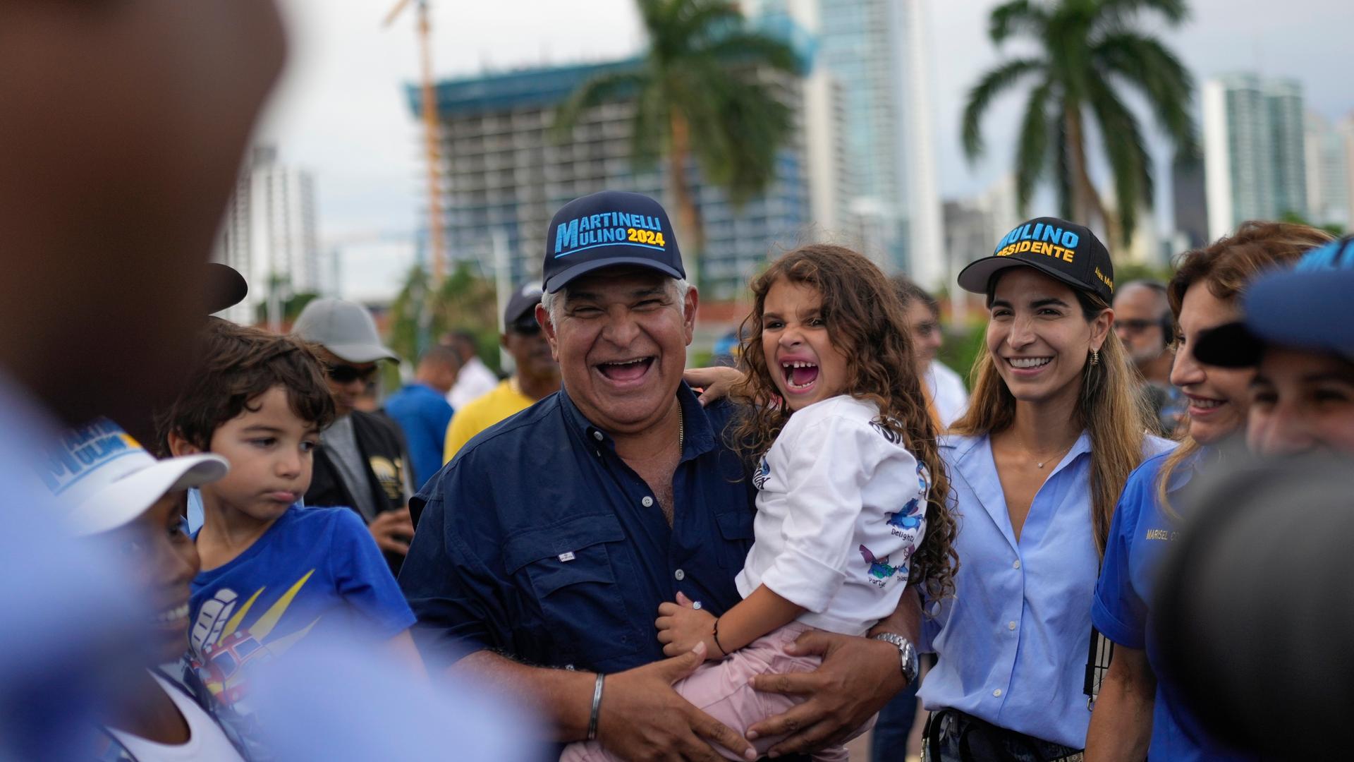 Präsidentschaftsbewerber Jose Raul Mulino zeigt sich mit seiner Tochter Sofia. Er trägt seine Enkeltochter auf dem Arm. Beide lachen. 
