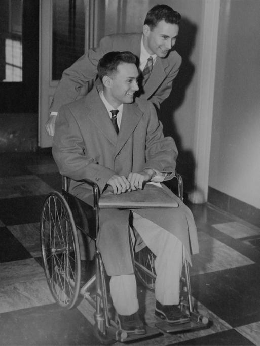Ron Herrick schiebt seinen Zwillingsbruder Richard in einem Rollstuhl, als sie am 30. Januar 1955 das Krankenhaus in Boston, Massachusetts, nach der ersten erfolgreichen Organtransplantation verlassen. 