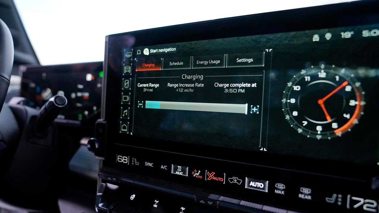 Der Bildschirm eine E-Autos. Rechts die Uhrzeit, links ein Balken, der das Aufladen der Batterie anzeigt. 