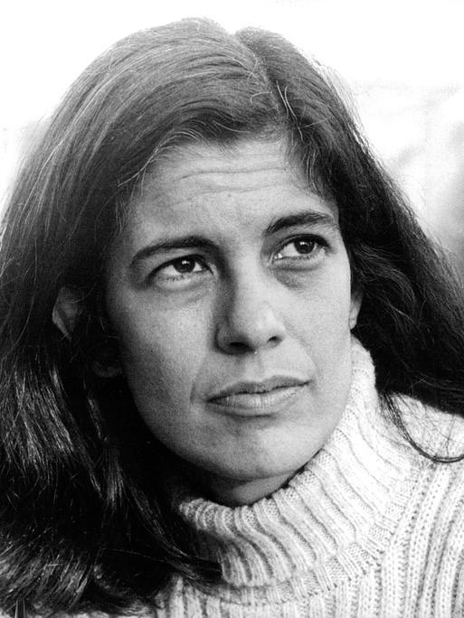 Die Archivaufnahme der 1933 geborenen Intellektuellen Susan Sontag entstand in Stockholm am 6. august 1970. Sie zeigt die Frau mit weißem Rollkragenpulli und langen dunklen Haaren. Sie schaut links an der Kamera vorbei in die Ferne.  