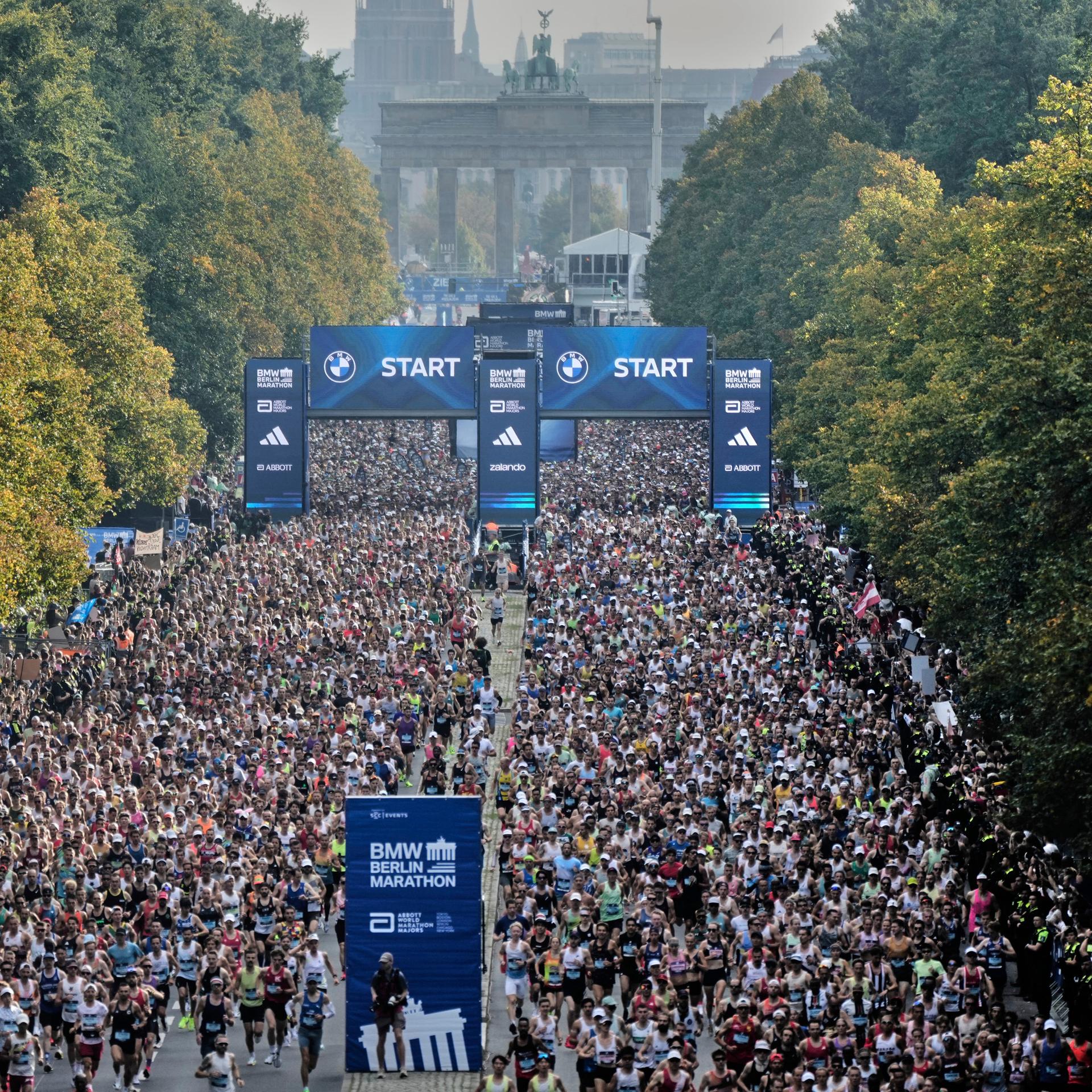 Tausende Läufer sind beim Berlin-Marathon 2025 am Start. Im Hintergrund ist das Brandenburger Tor zu sehen.