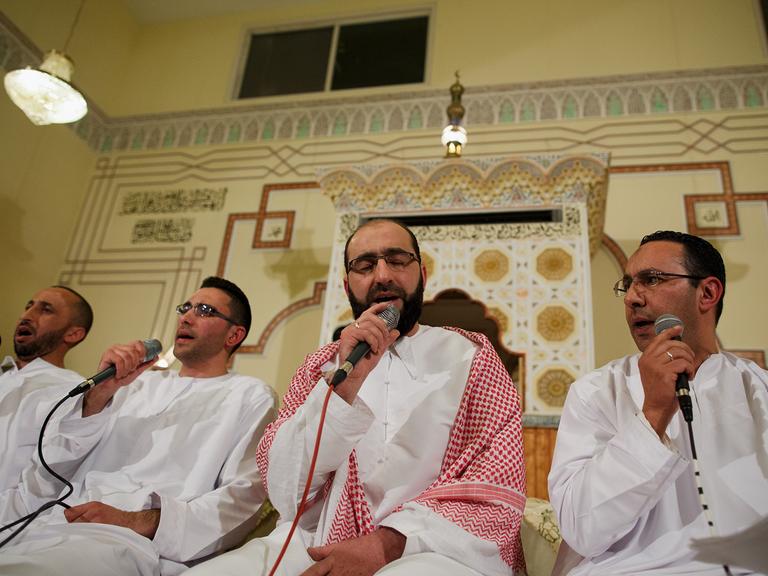 Muslimische Männer singen gemeinsam bei einer Feier in einer Moschee. (Symbolbild)