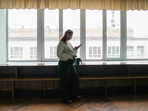 Die schwangere Studentin Alisa Khokhlova an der Staatlichen Dobrolyubov-Universität in Nischni Nowgorod, Russland. Sie steht alleine an einem Fenster und hält ihren Bauch.