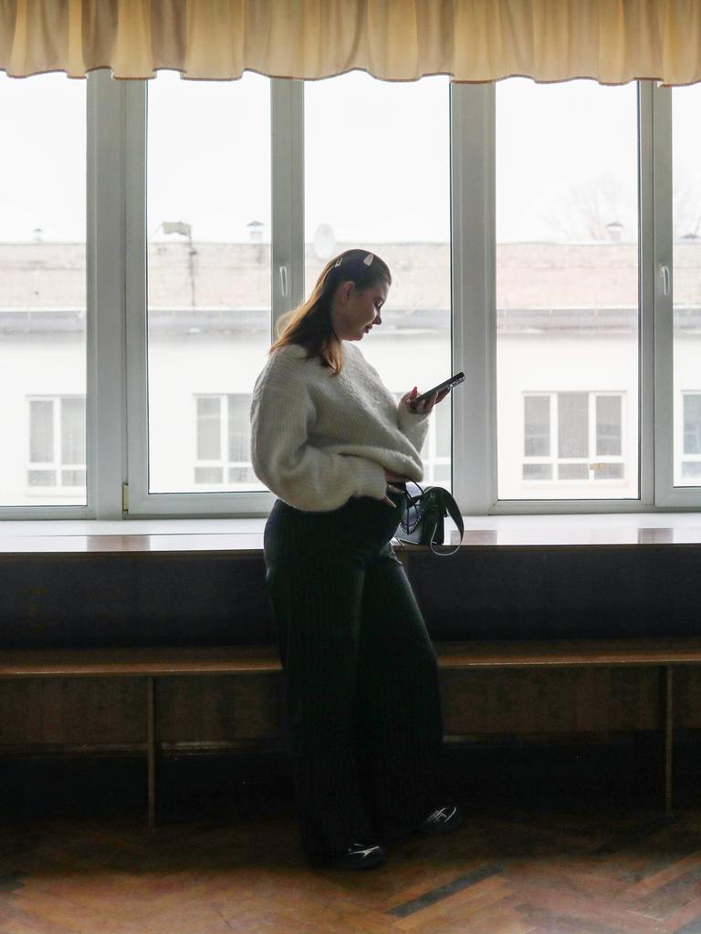 Die schwangere Studentin Alisa Khokhlova an der Staatlichen Dobrolyubov-Universität in Nischni Nowgorod, Russland. Sie steht alleine an einem Fenster und hält ihren Bauch.
