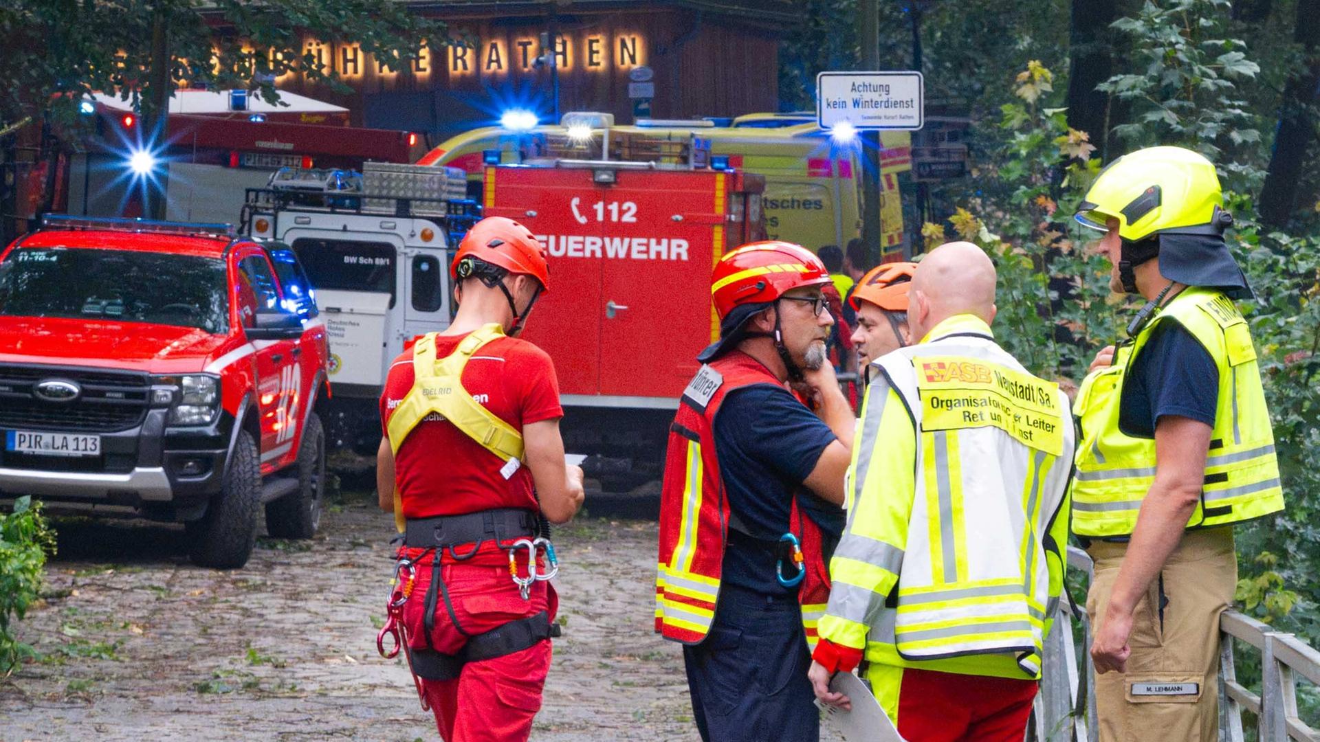 Einsatzkräfte stehen im Bereich der Felsenbühne Rathen. Bei einem Unwetter in Sachsen ist ein Mann ums Leben gekommen. Er wurde in Rathen von einem umgestürzten Baum erschlagen. Einsatzkräfte stehen im Bereich der Felsenbühne Rathen. Bei einem Unwetter in Sachsen ist ein Mann ums Leben gekommen. Er wurde in Rathen von einem umgestürzten Baum erschlagen.