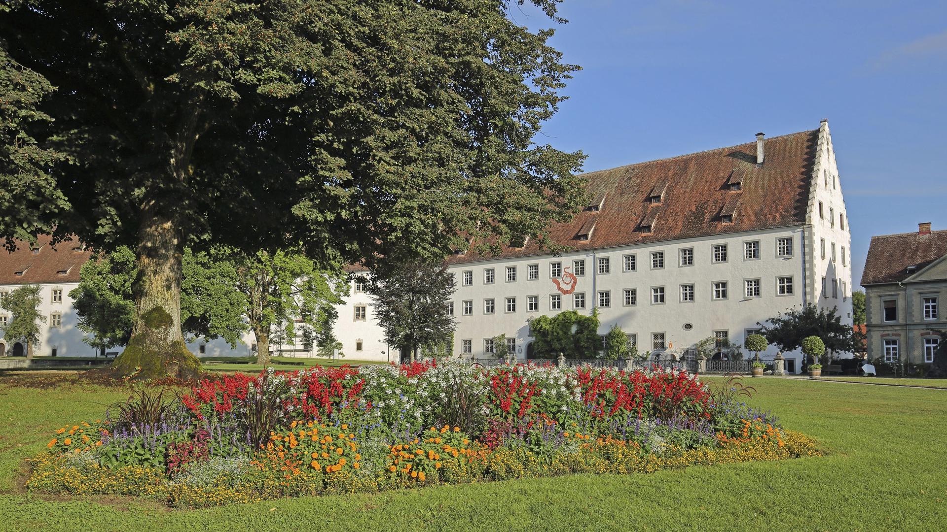 Schloss Salem in Baden-Württemberg. Im Vordergrund eine Wiese mit Blumenbeet