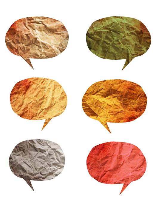 Eine Grafik zum Thema Mehrsprachigkeit: Sprechblasen aus Papier und in verschiedenen Farben sind auf einem weißen Hintergrund.