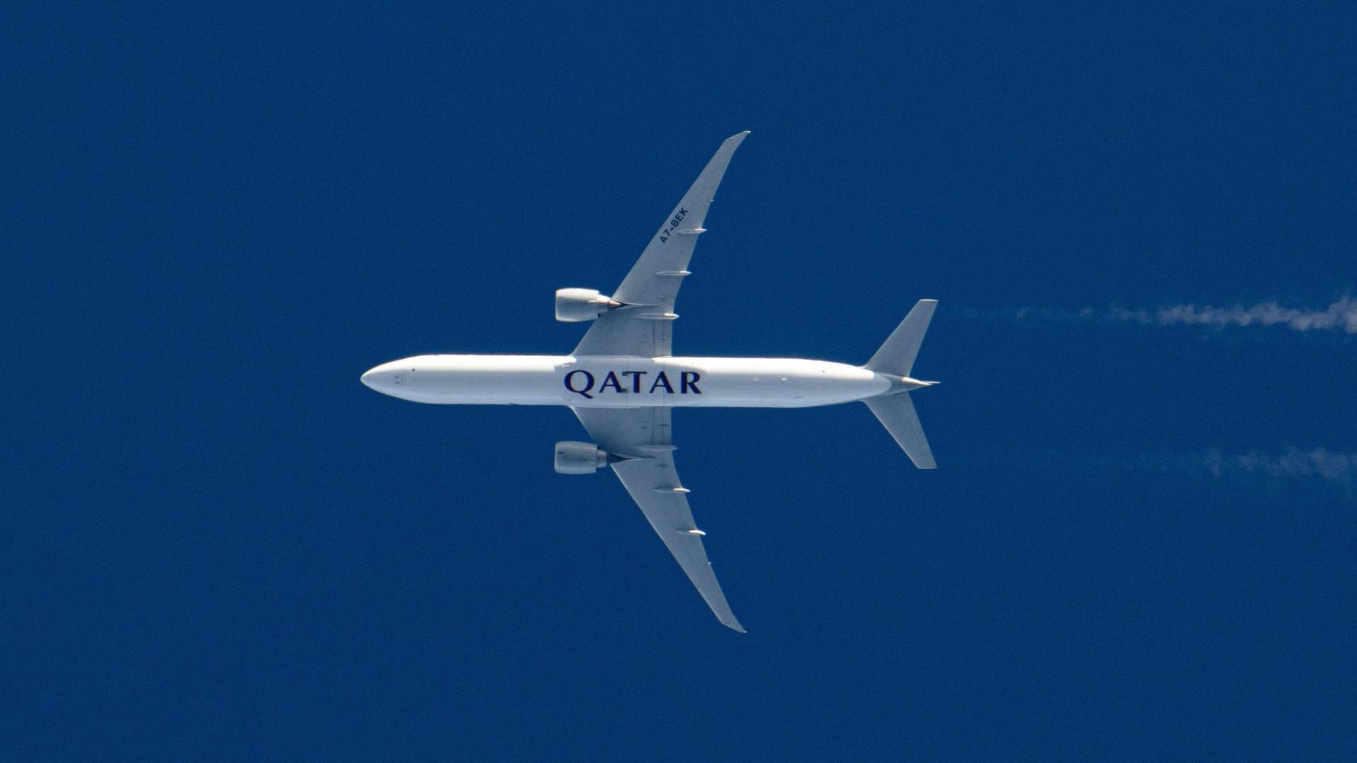 Rumpf einer fliegenden Qatar Airways Boeing 777 vom Boden aus gesehen