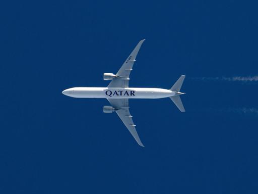 Rumpf einer fliegenden Qatar Airways Boeing 777 vom Boden aus gesehen
