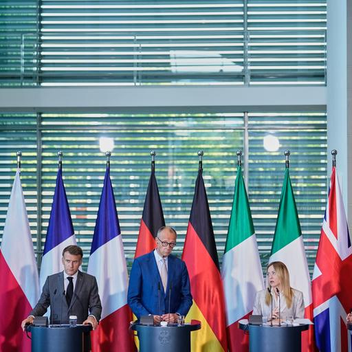 Donald Tusk, Emmanuel Macron, Friedrich Merz, Giorgia Meloni und Keir Starmer stehen bei einer Pressekonferenz nebeneinander.