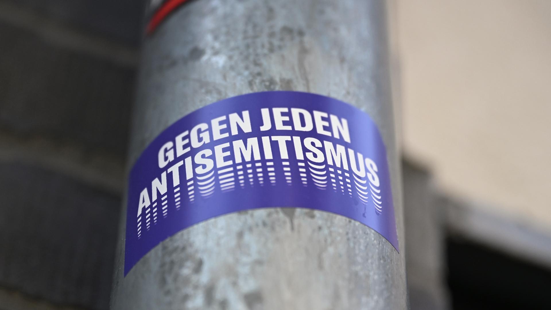 Ein Sticker mit der Aufschrift "Gegen jeden Antisemitismus" hängt an einem Laternenmast. Ein Sticker mit der Aufschrift "Gegen jeden Antisemitismus" hängt an einem Laternenmast.