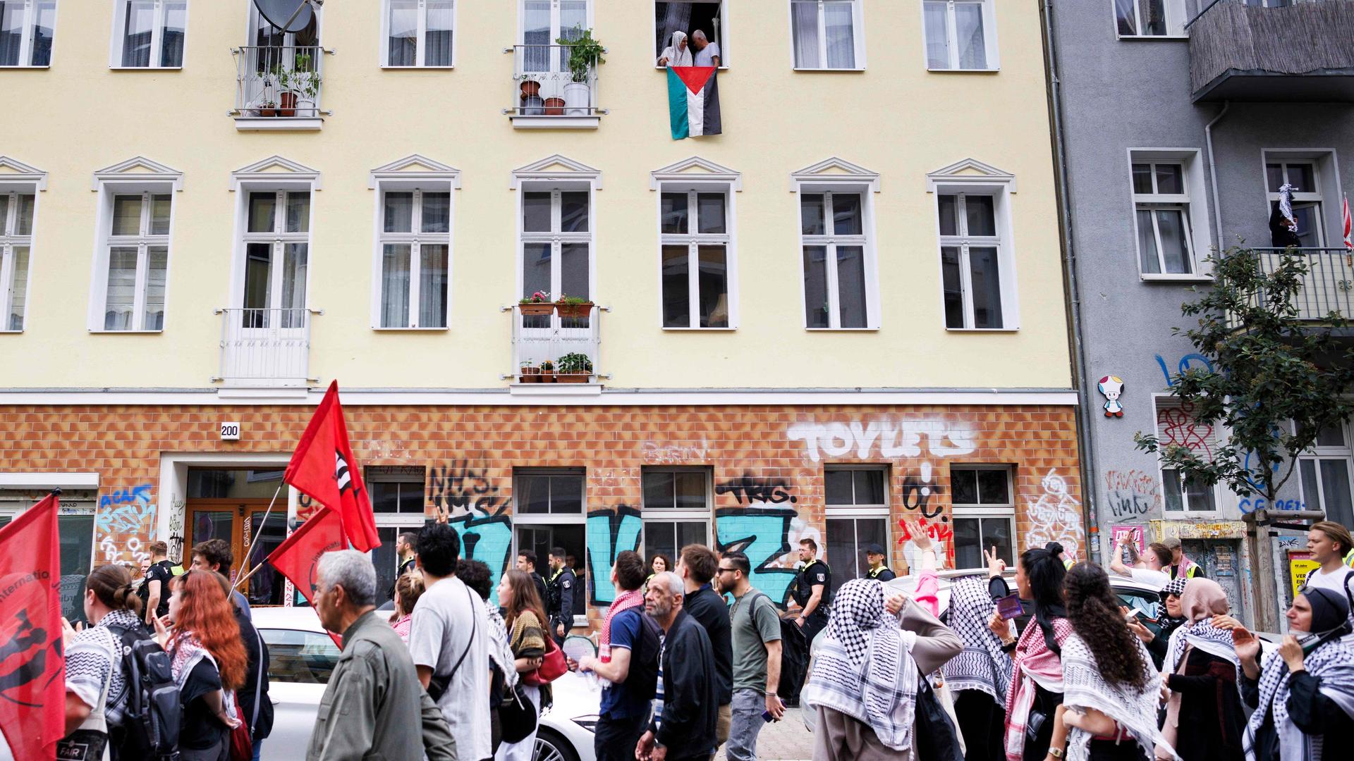 Anwohner halten eine palästinensische Fahne während der Demonstration «Schulstreik für Palästina» im Stadtteil Neukölln aus dem Fenster.