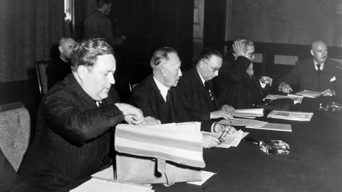 Mitglieder des Parlamentarischen Rats der Bundesrepublik Deutschland sitzen an einem Tisch. V.li.: Carlo Schmid, Konrad Adenauer, Anton Pfeiffer und Theophil Kaufmann.
