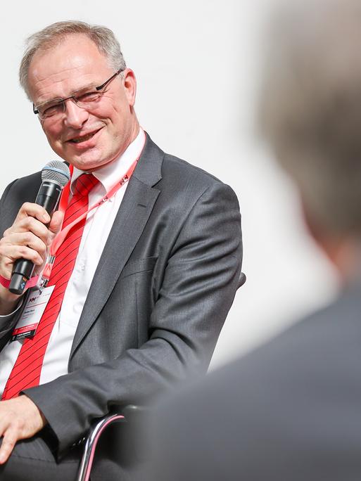 Stefan Raue, Intendant des Deutschlandradio, hier 2021 auf einem Podium der Medientage Mitteldeutschland mit Mikrofon in der Hand