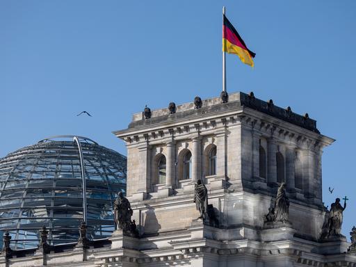 Das Reichtagsgebäude mit der gläsernen Kuppel vor blauem Himmel