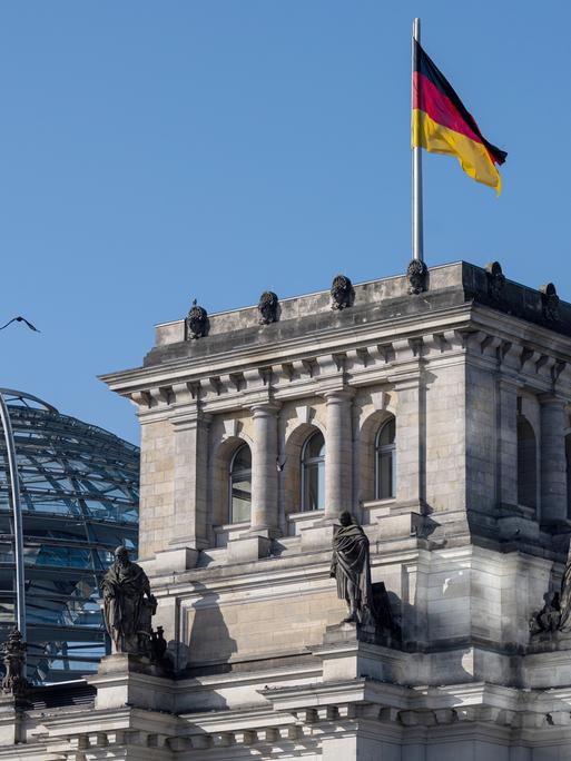 Das Reichtagsgebäude mit der gläsernen Kuppel vor blauem Himmel