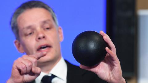 Der Physiker Ulf Danielsson blickt auf eine schwarze Kugel in seiner Hand und erklärt anhand dieses Modells eine Theorie