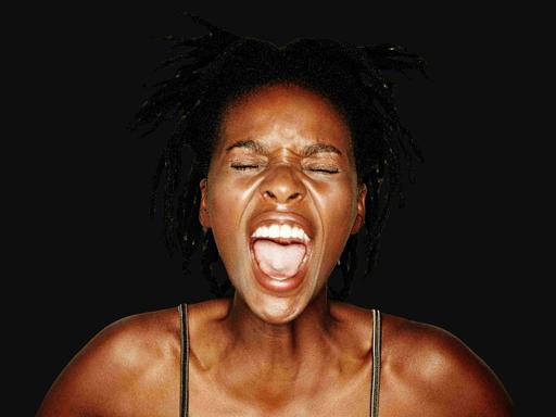 Junge schreiende Frau vor schwarzem Hintergrund