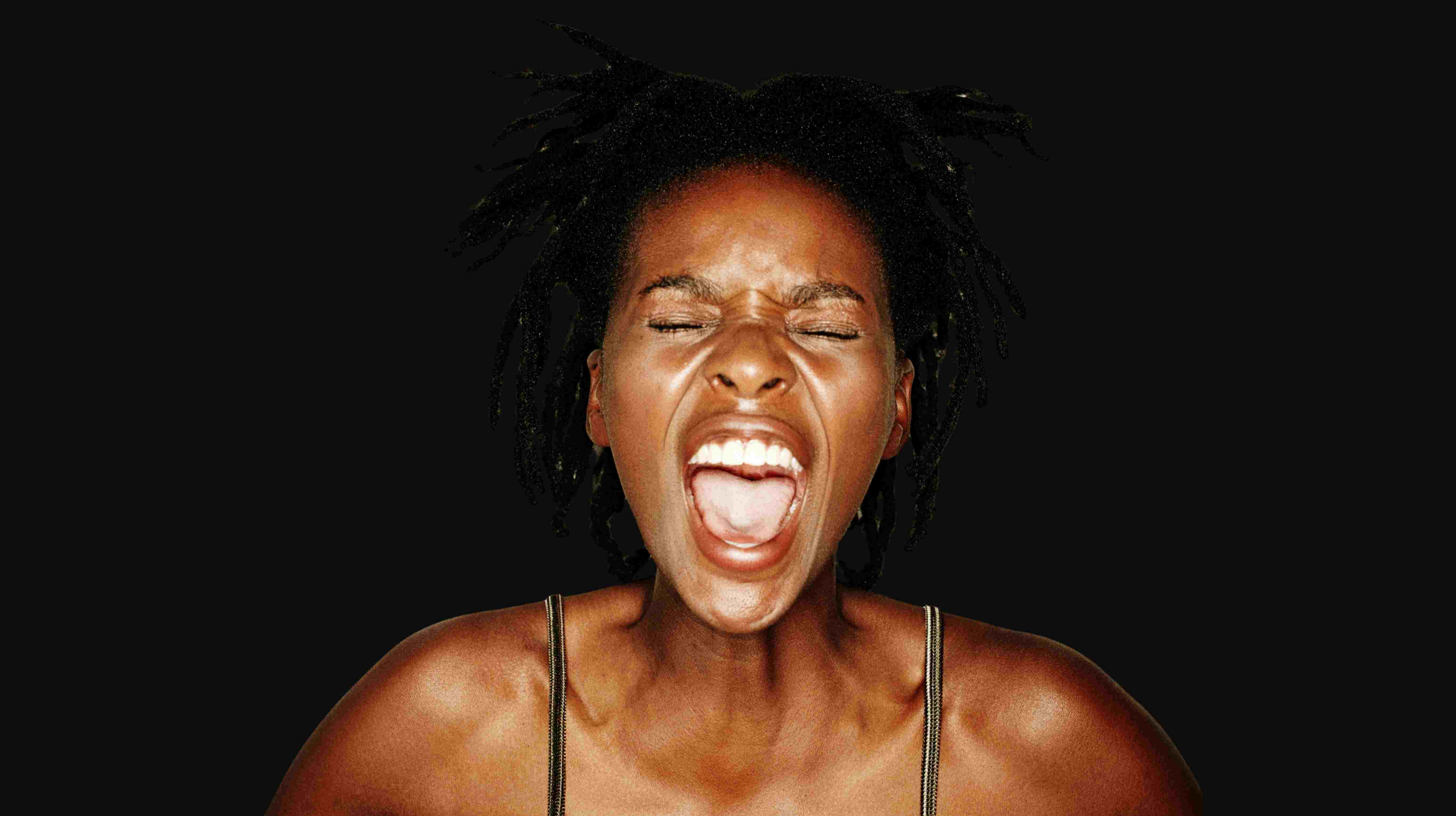 Junge schreiende Frau vor schwarzem Hintergrund