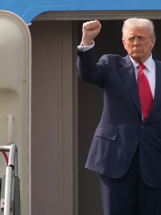 US-Präsident Donald Trump geht an Bord der Air Force One und streckt die rechte Faust in die Höhe
