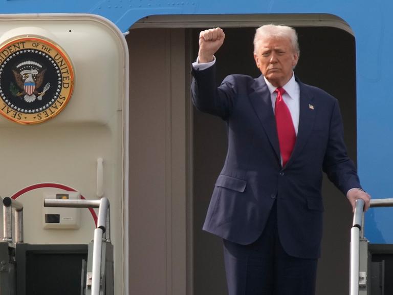 US-Präsident Donald Trump geht an Bord der Air Force One und streckt die rechte Faust in die Höhe