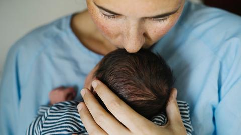 Eine Mutter küsst ihr Baby.