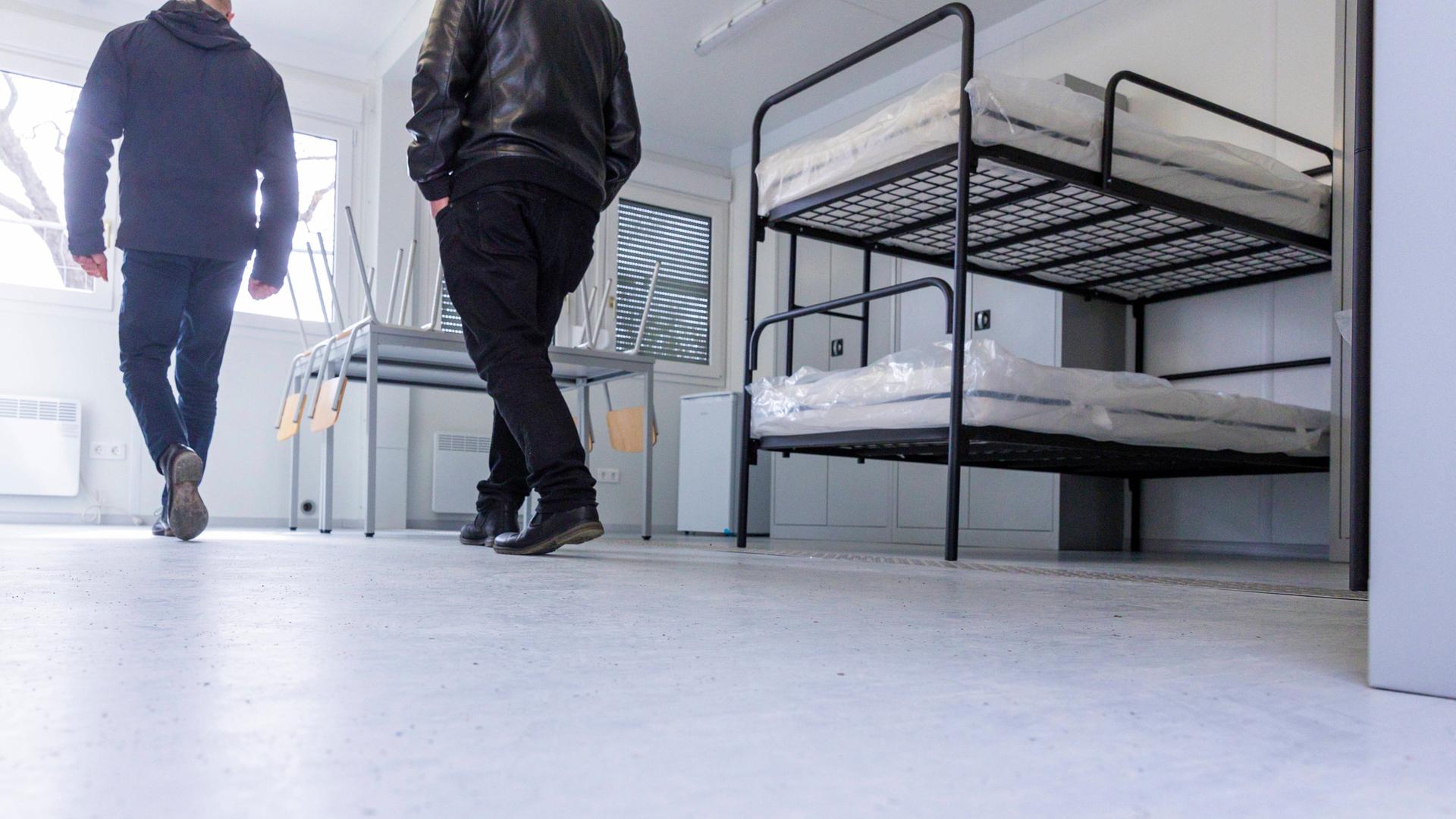 Zwei Personen gehen durch die Räumlichkeiten der Flüchtlingsunterkunft in Dresden-Sporbitz. Die Matratzen der Etagenbetten sind noch mit Plastik umhüllt. Zwei Personen gehen durch die Räumlichkeiten der Flüchtlingsunterkunft in Dresden-Sporbitz. Die Matratzen der Etagenbetten sind noch mit Plastik umhüllt.