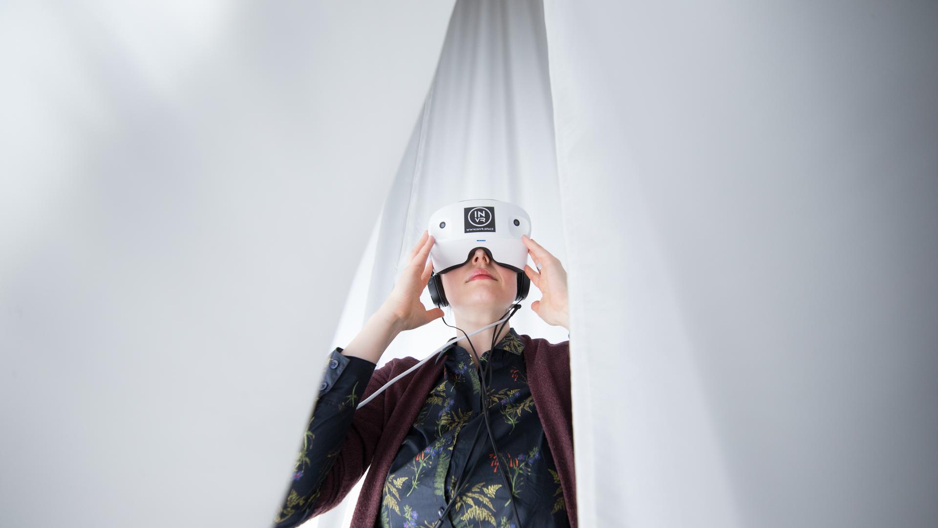 Eine Frau trägt eine Virtual-Reality-Brille. Eine Frau trägt eine Virtual-Reality-Brille.