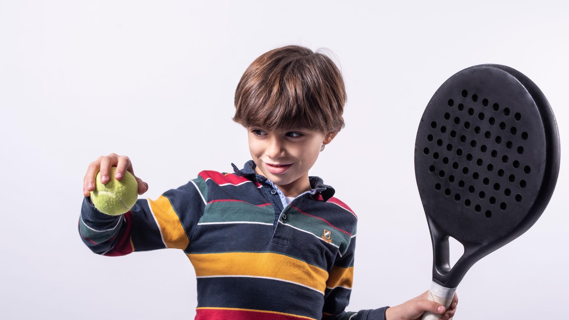 Ein Junge mit Schläger und Ball beim Padel-Tennis Ein Junge mit Schläger und Ball beim Padel-Tennis