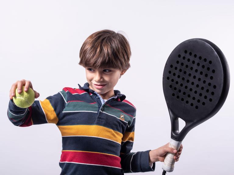 Ein Junge mit Schläger und Ball beim Padel-Tennis