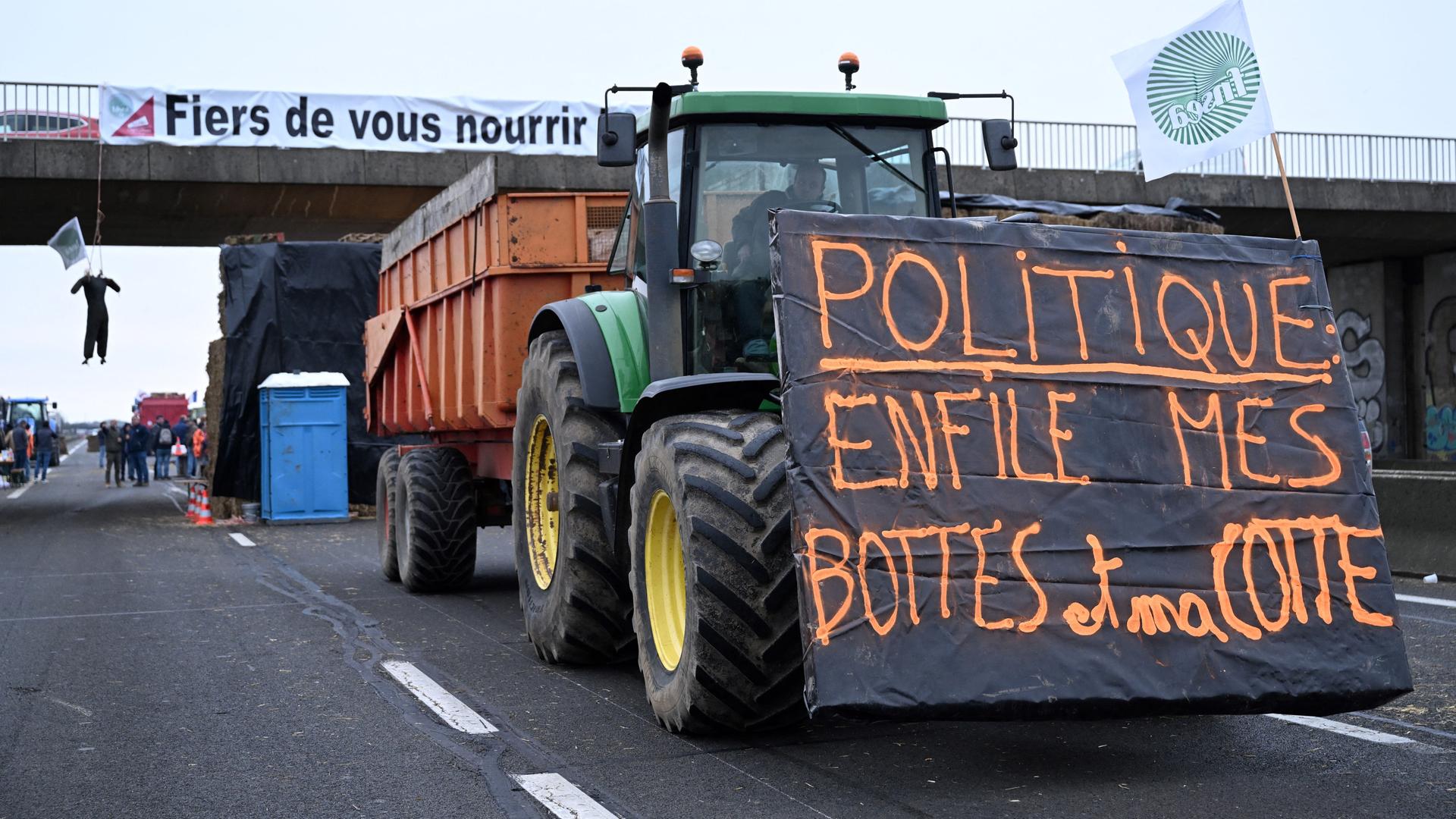 Tranktoren fahren auf der A4 im Osten von Paris und blockieren die Autobahn. An einer Brücke hängt ein Banner mit der Aufschrift "Wir sind stolz, Sie zu füttern."