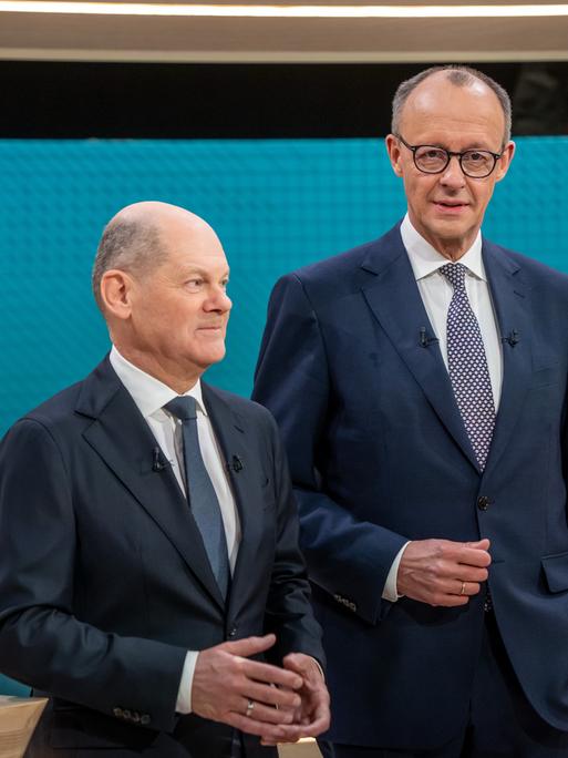 Bundeskanzler Olaf Scholz steht neben CDU-Kanzlerkandidat Friedrich Merz, vor dem TV-Duell von ARD und ZDF im Fernsehstudio.