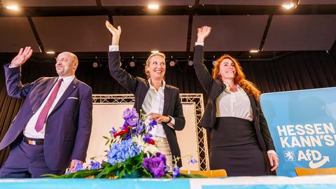 Robert Lambrou (l-r, AfD), AfD-Landesvorsitzender/Spitzenkandidat zur Landtagswahl, Alice Weidel (AfD), Bundesparteivorsitzende, und Mariana Harder-Kühnel (AfD), eine von drei stellvertretenden Bundessprechern ihrer Partei, stehen winkend und lachend auf dem Podium zusammen. 