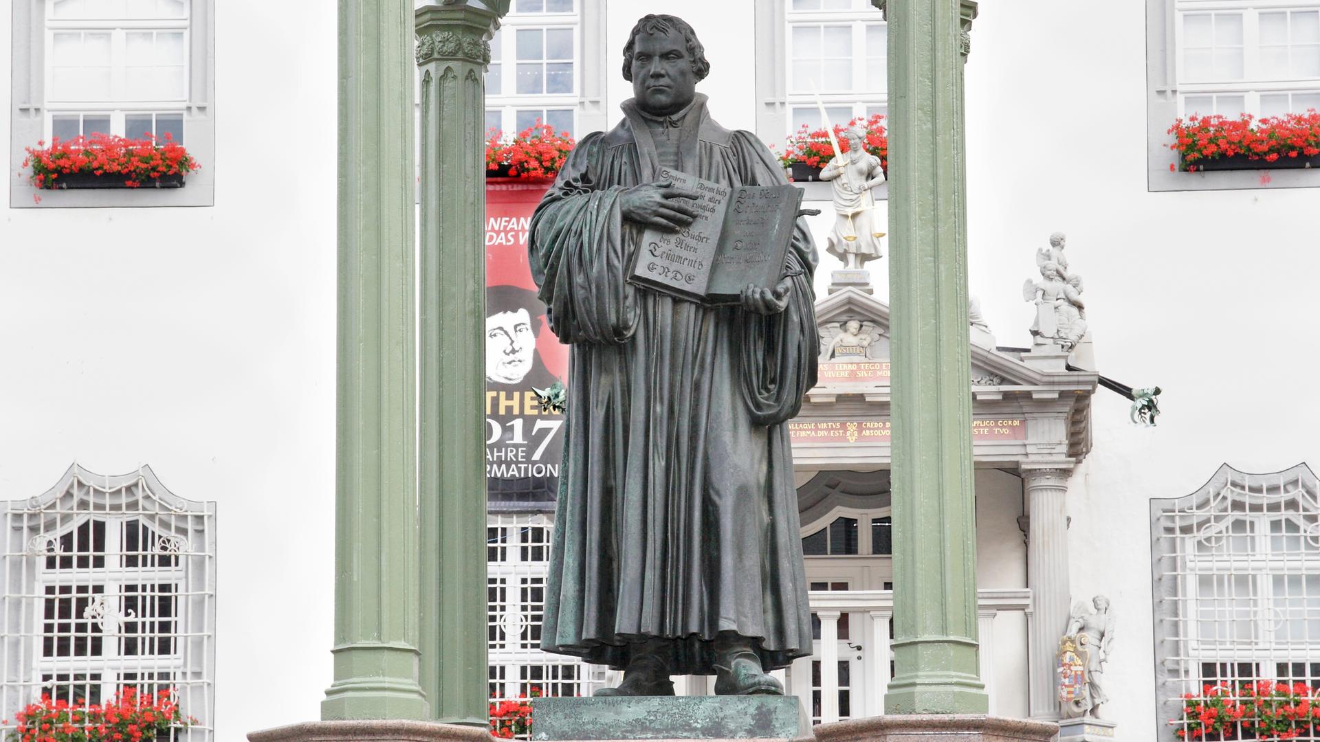 Das Denkmal des Reformators Martin Luther mit der von ihm in die deutsche Spracheübersetzten Bibel auf dem Marktplatz der Lutherstadt Wittenberg an der Elbe in Sachsen Anhalt.