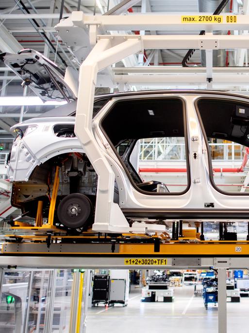 Die Karosserie für ein vollelektrisches Fahrzeug vom Typ Volkswagen ID.4 wird auf einem Transportsystem durch eine Halle im Volkswagen-Werk Emden transportiert. 