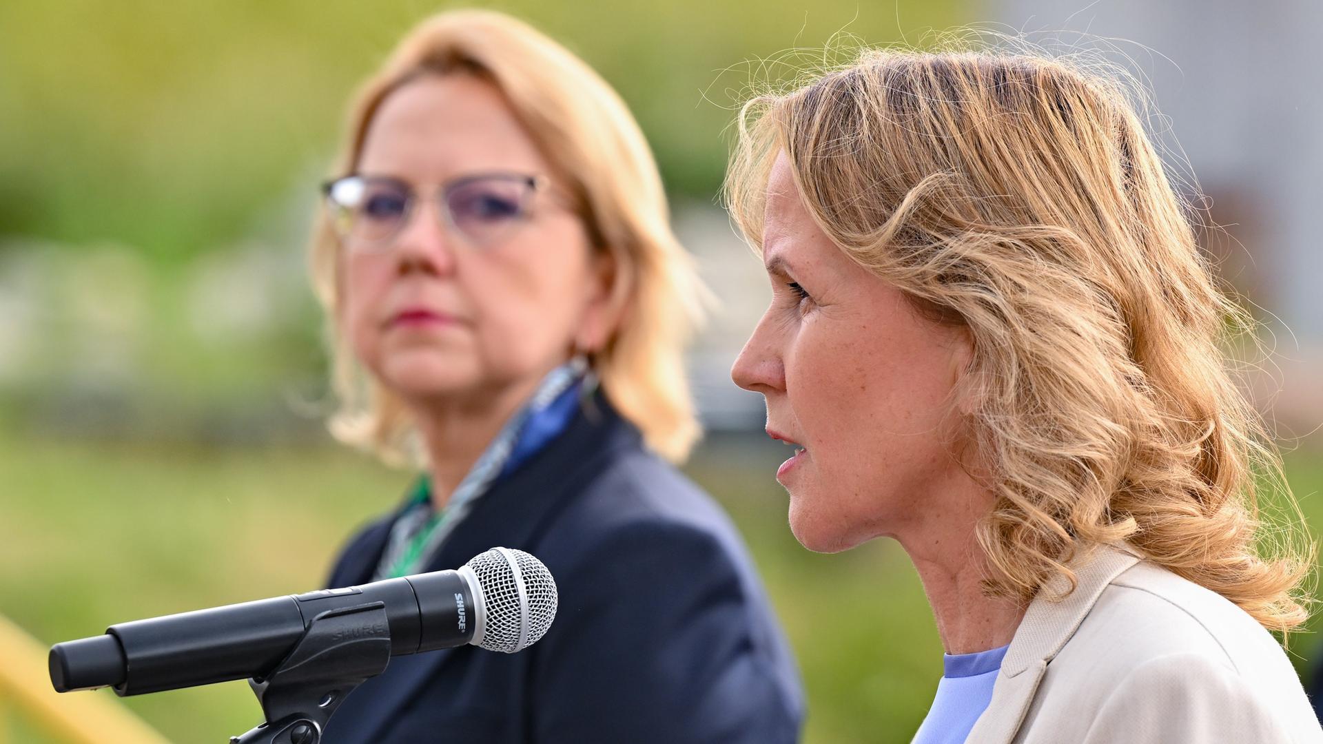 Das Foto zeigt Bundesumweltministerin Steffi Lemke. Sie spricht in ein Mikrofon. Im Hintergrund ist ihre polnische Amtskollegin Anna Moskwa zu sehen.