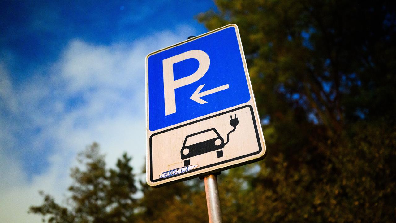 Ein Schild markiert einen Parkplatz für ein Elektroauto an einer öffentlichen Schnellladesäule. 