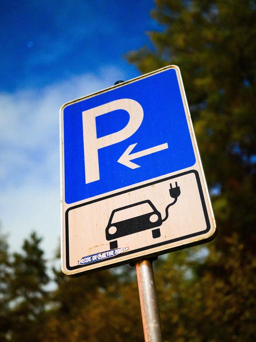 Ein Schild markiert einen Parkplatz für ein Elektroauto an einer öffentlichen Schnellladesäule. 