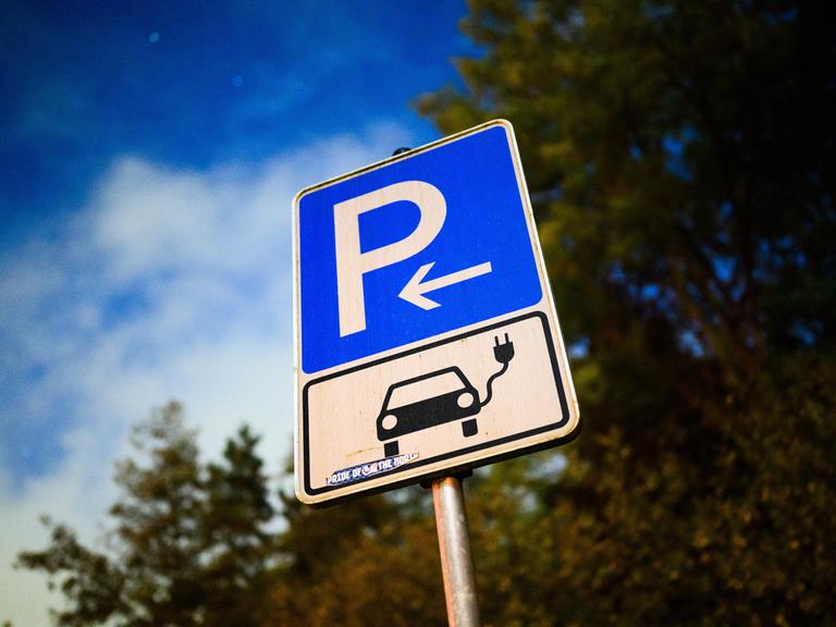 Ein Schild markiert einen Parkplatz für ein Elektroauto an einer öffentlichen Schnellladesäule. 