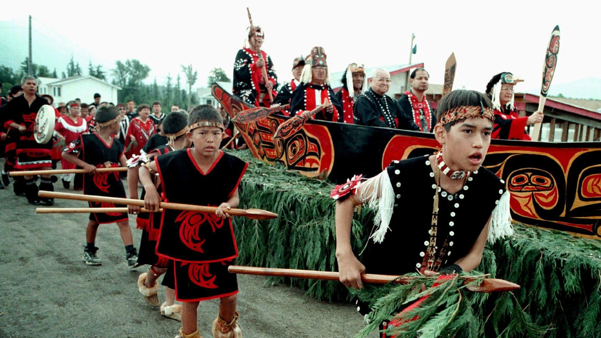 Junge Nisga'a begleiten eine Delegation der Ältesten in traditionellen Gewändern zur Unterzeichnung der Nisga'a-Verträge 1998. Junge Nisga'a begleiten eine Delegation der Ältesten in traditionellen Gewändern zur Unterzeichnung der Nisga'a-Verträge 1998.