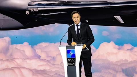 NATO-Generalsekretär Mark Rutte spricht am Rednerpult vor einer Leinwand, auf der das GlobalEye-Flugzeug von Saab präsentiert wird.