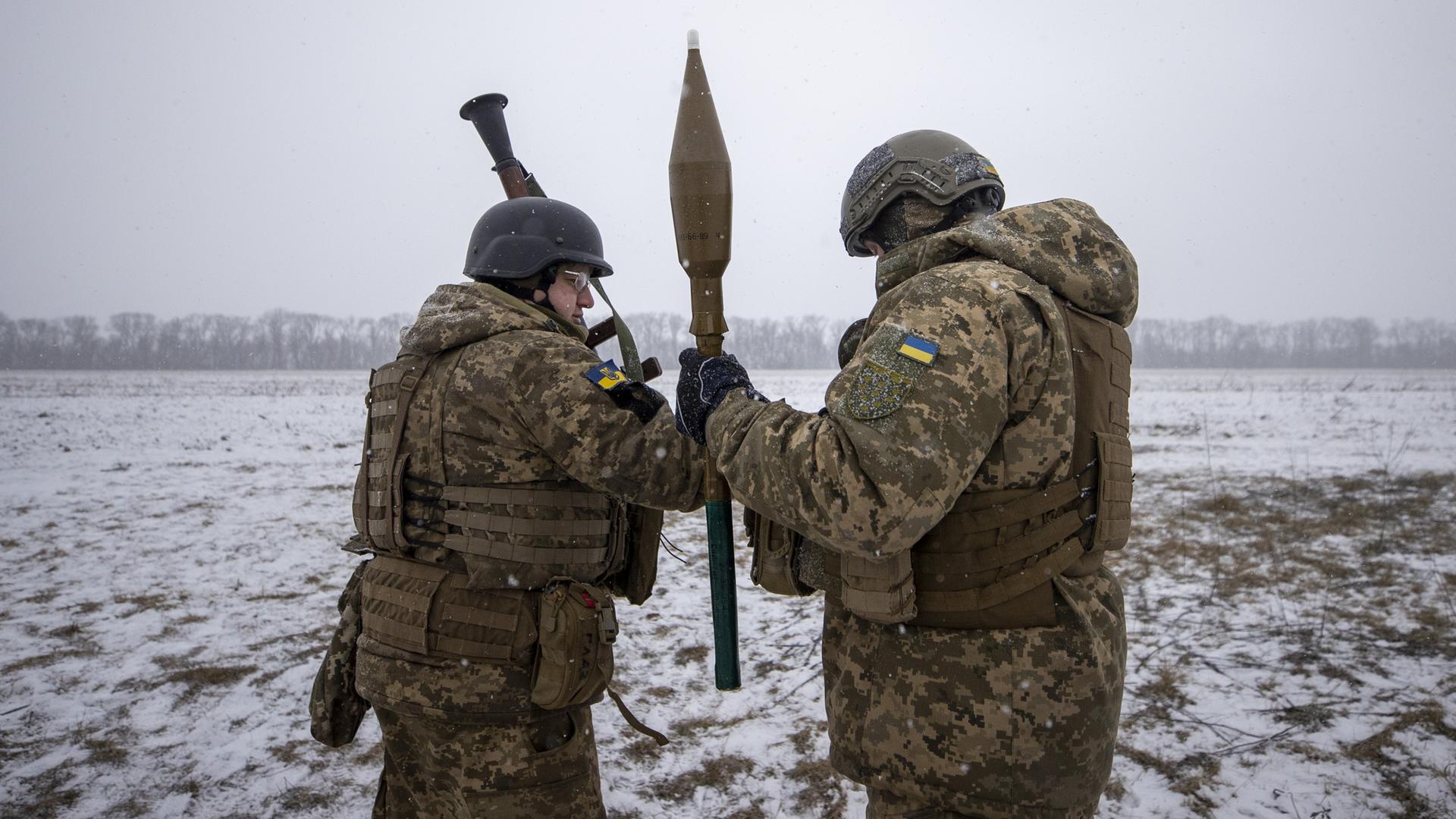Zwei ukrainische Soldaten mit Panzerfaust in einem verschneiten Feld.