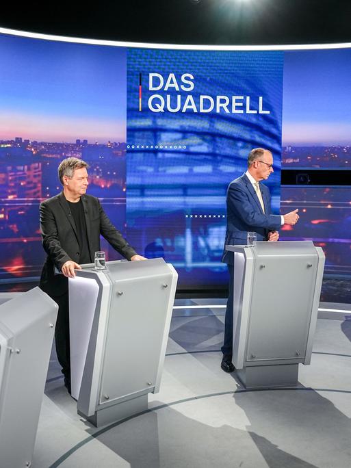 Olaf Scholz, Robert Habeck, Friedrich Merz und Alice Weidel stehen nebeneinander vor Pulten in einer TV-Diskussion.