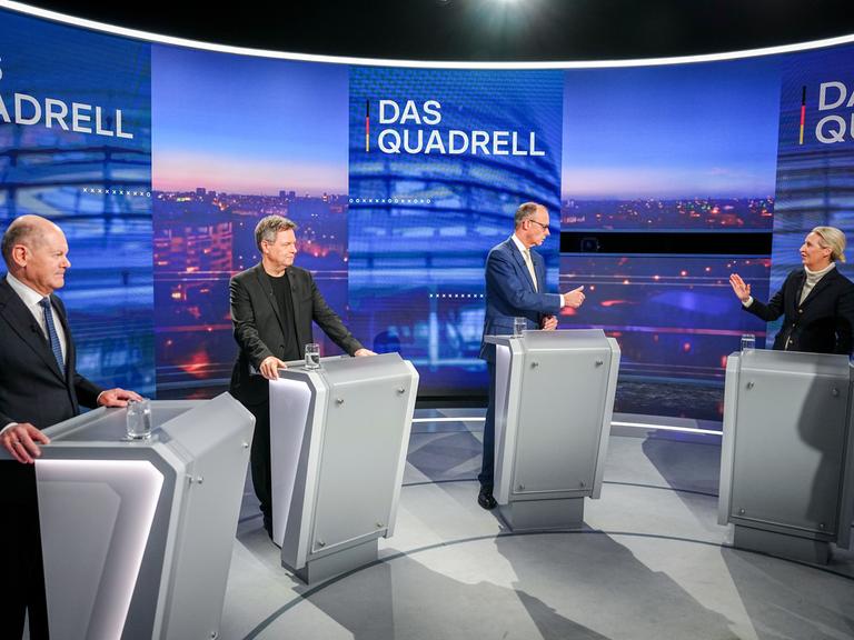 Olaf Scholz, Robert Habeck, Friedrich Merz und Alice Weidel stehen nebeneinander vor Pulten in einer TV-Diskussion.