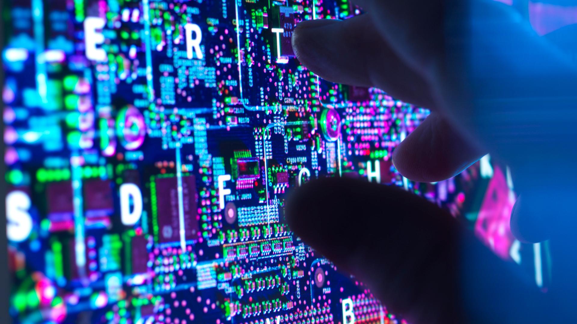 Eine dunkle Hand an einem Computerbildschirm 