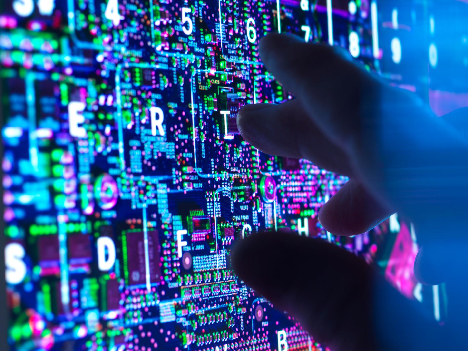 Eine dunkle Hand an einem Computerbildschirm 