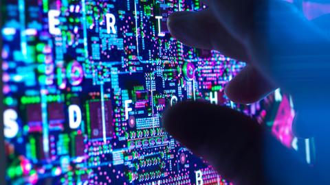 Eine dunkle Hand an einem Computerbildschirm 